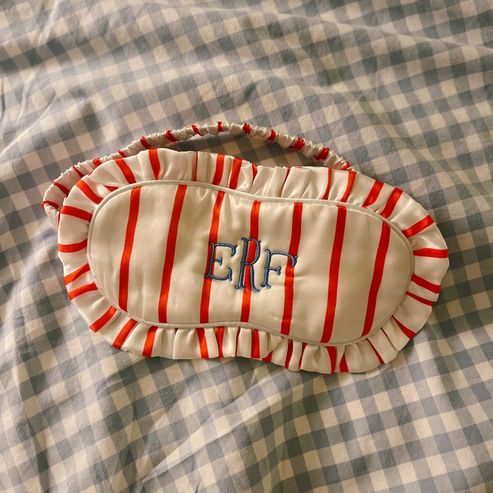 Red and white striped eye mask with 'ERF' initials embroidered onto it